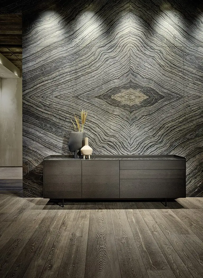 Sideboard aus dunklem Holz vor einer großformatig marmorierten Wand
