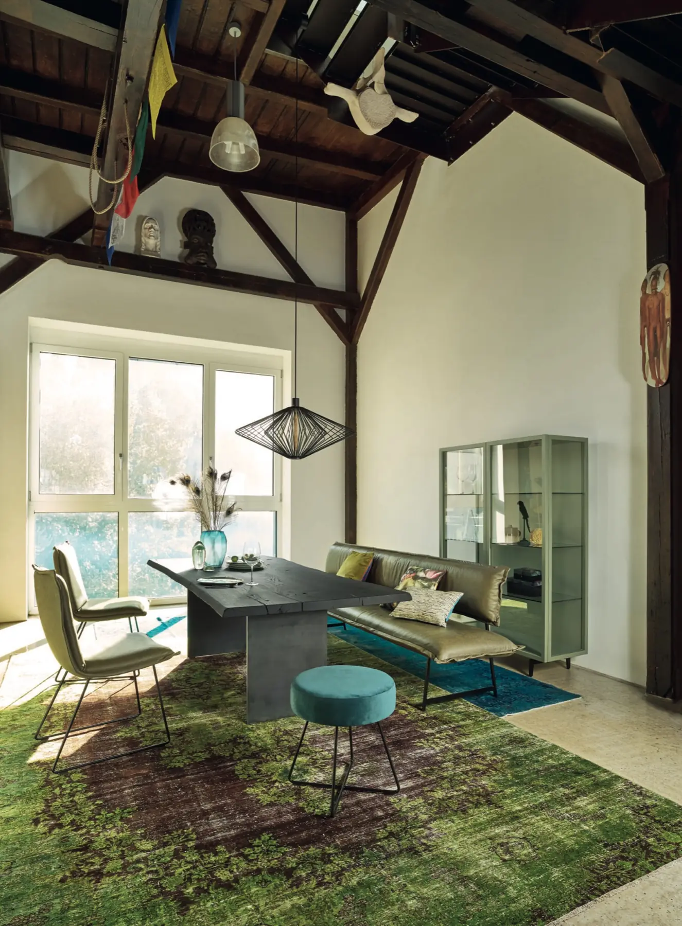 Essplatz unter einem alten Dachstuhl mit farbigen Stühlen