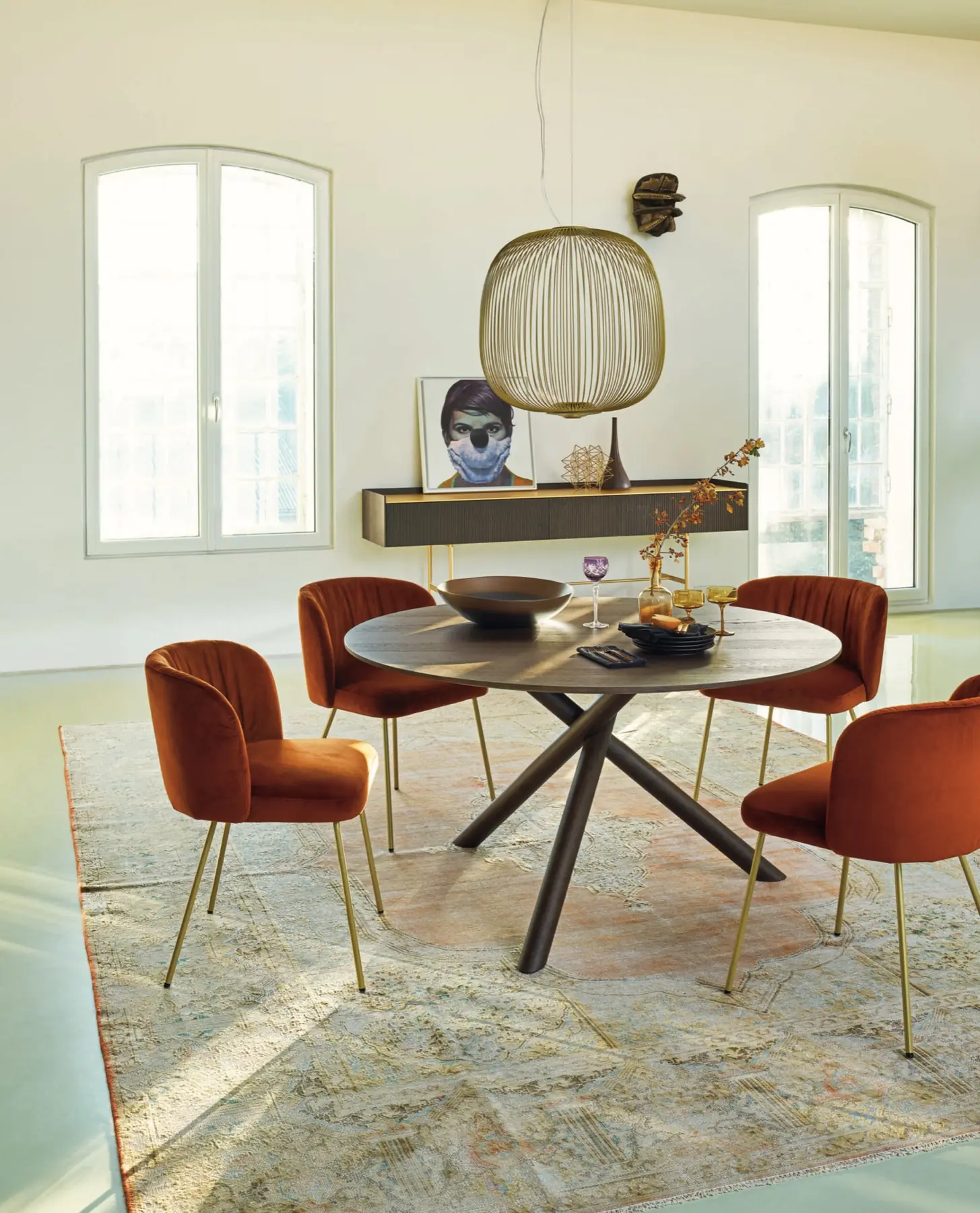 Runder Esstisch mit roten Polsterstühlen und Sideboard