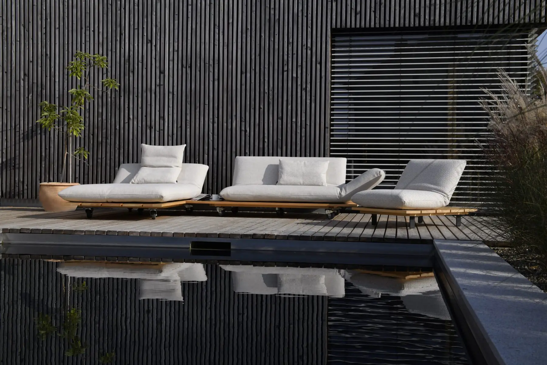 Weiße Outdoor-Loungemodule Akito auf einer Terrasse am Wasser