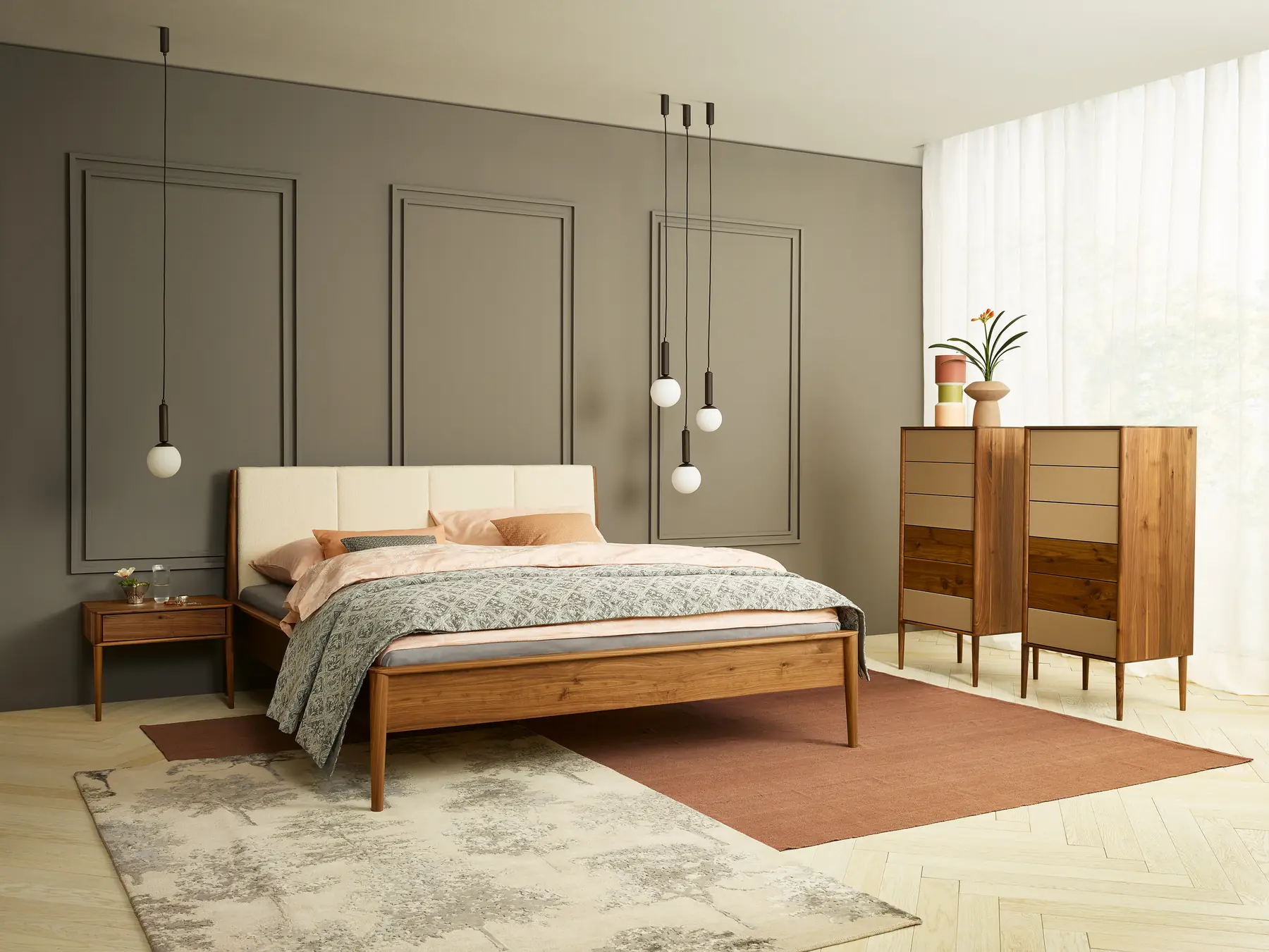Schlafzimmer mit Polsterkopfteil vor grauer Wandvertäfelung