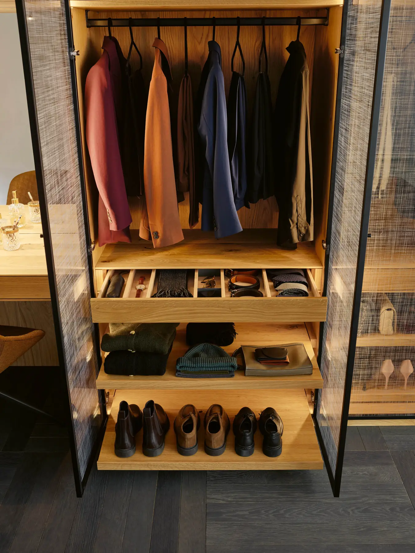 Geöffneter Kleiderschrank mit Kleiderstange, Schubladen und Schuhfächern