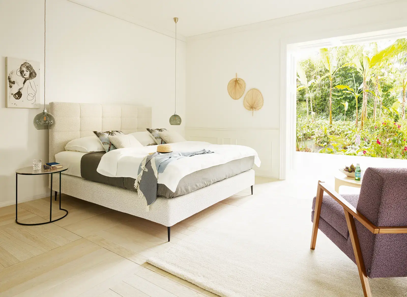 Boxspringbett Mattina mit weißem Bettzeug vor einer Fensterfront mit Gartenblick