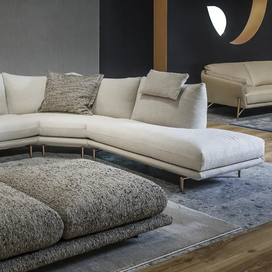 Nahaufnahme eines hellen Ecksofas Dragees mit Kissen und rundem Beistelltisch