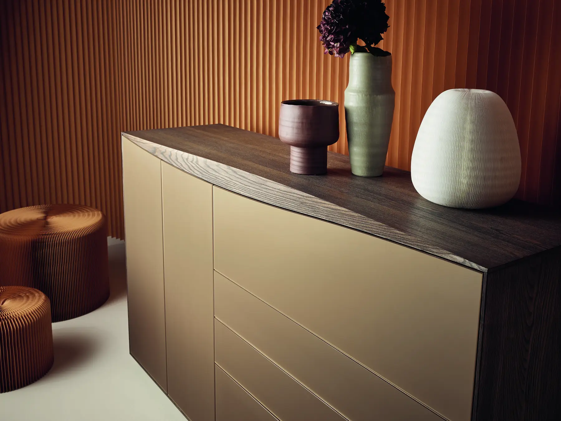 Detail eines Sideboards mit gerillter Deckplatte, beigen Fronten und dekorativen Vasen