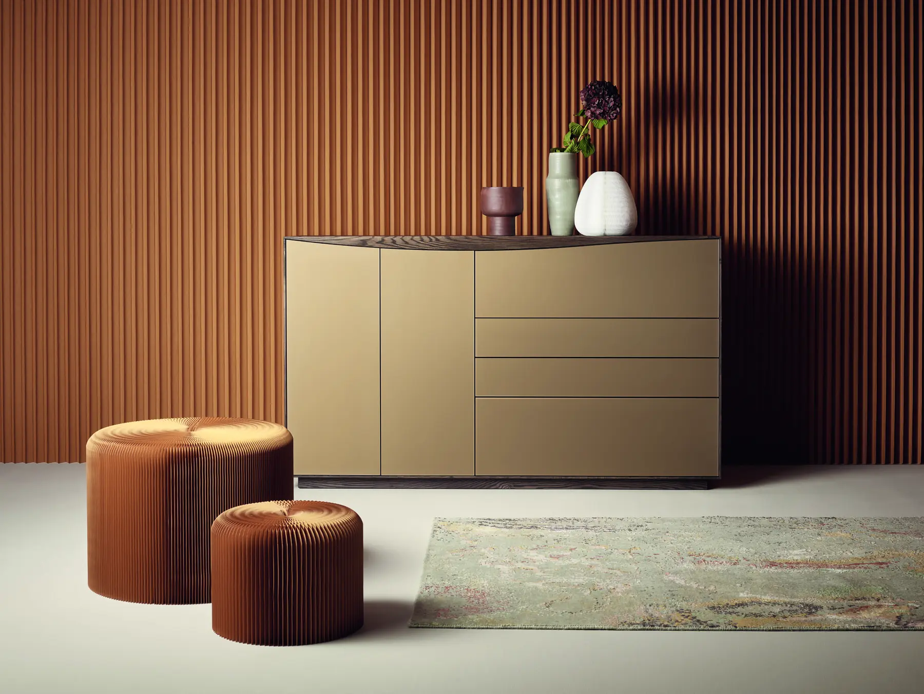 Kompaktes beigefarbenes Sideboard mit Schubladen vor einer dunklen Lamellenwand