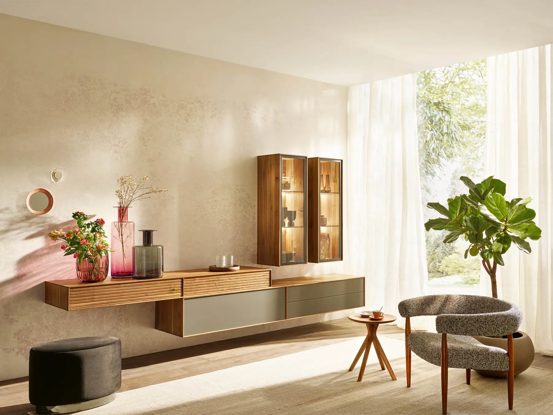 Lange Wohnkombination aus dunklem Holz mit grauen Fronten und beleuchteter Vitrine